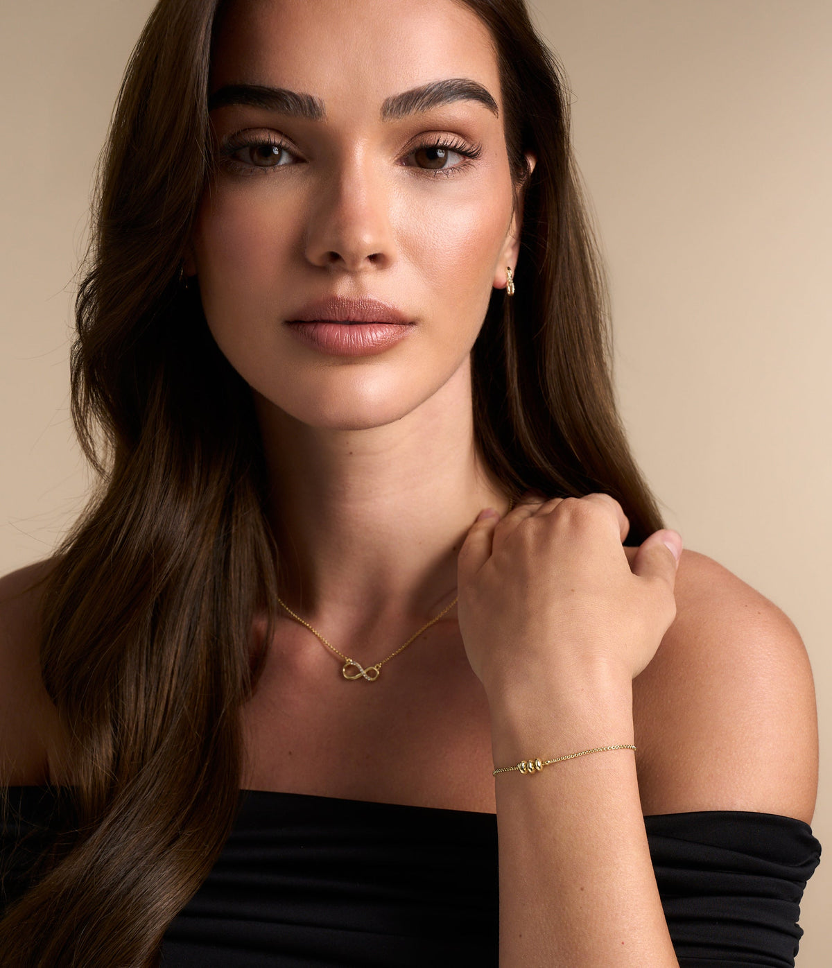 Model wears a gold tone bracelet from the Buckley London gifting capsule